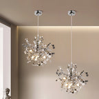 Two modern chandeliers hanging from the ceiling in a room with neutral walls.