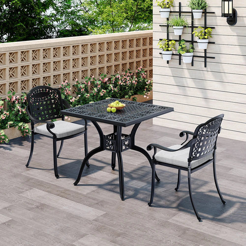 Outdoor patio set with black table and chairs on a wooden deck.