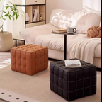Two quilted ottomans, one brown and one black, in a living room setting.
