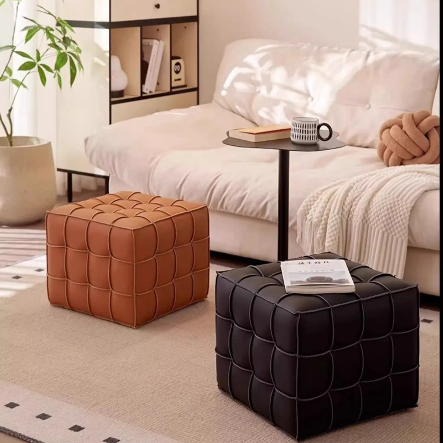 Two quilted ottomans, one brown and one black, in a living room setting.