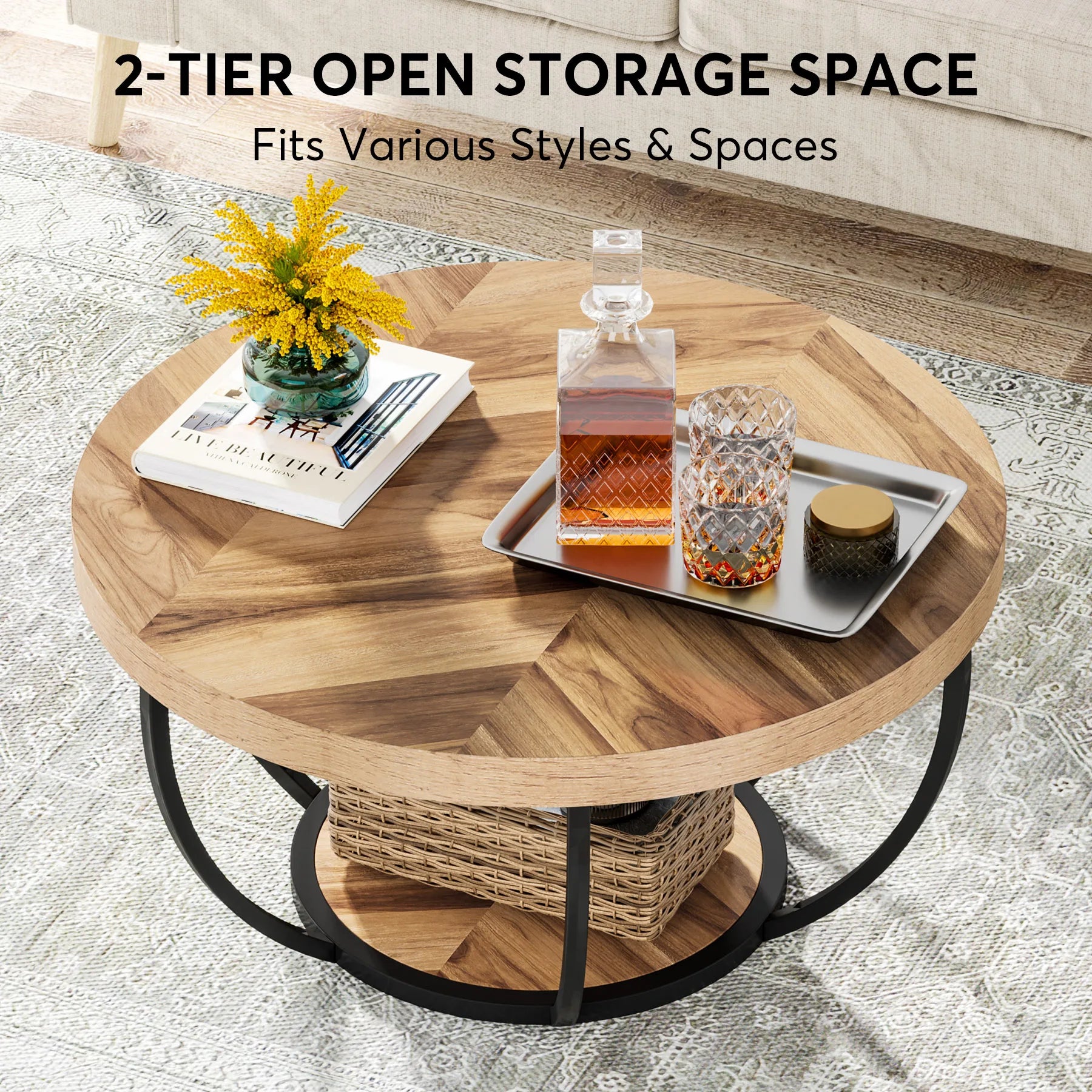 Round wooden coffee table with a tray holding a decanter, glass, and other items on a textured floor.