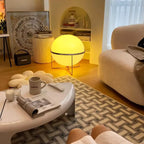 Modern living room with a round table, sofa, and decorative lamp.