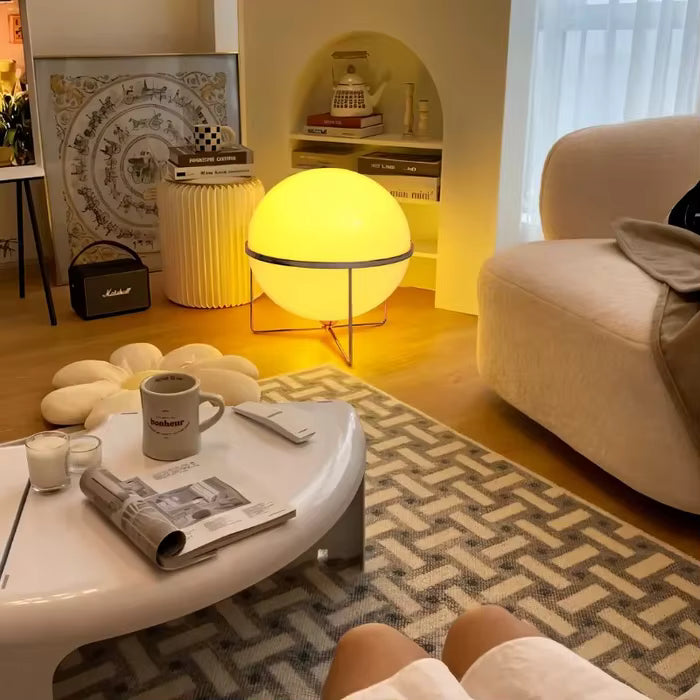 Modern living room with a round table, sofa, and decorative lamp.