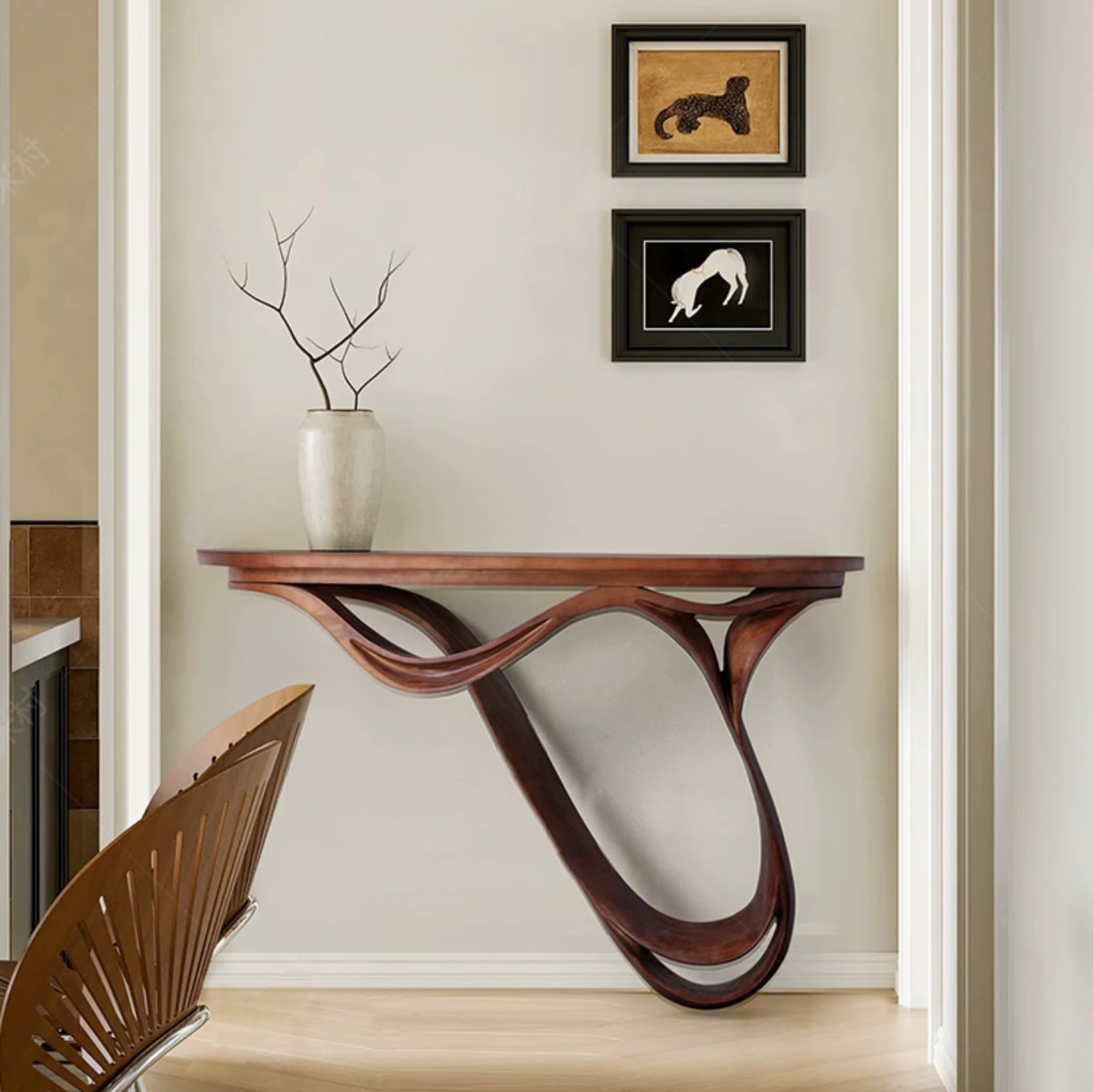 Wooden console table with wavy design against a wall with framed pictures.