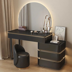 Modern black vanity table with round mirror and chair in a room setting.