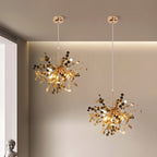 Two gold chandelier lights hanging in a room with neutral walls.