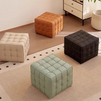 Four tufted ottomans in different colors on a patterned rug.