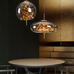 Two modern pendant lights hanging above a table with a dark wall and wooden panel in the background.