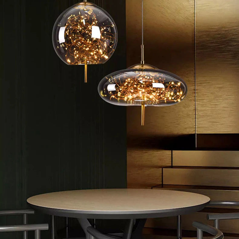 Two modern pendant lights hanging above a table with a dark wall and wooden panel in the background.