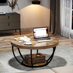 Round wooden coffee table with a laptop, mug, and books in a living room setting.