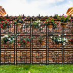 Decorative metal fence with floral pots on a brick wall