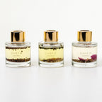 Three Shifa perfume bottles with gold caps on a white background