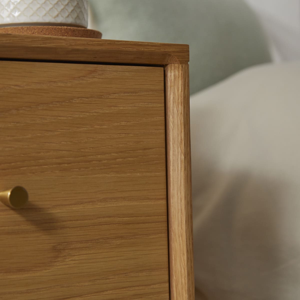 Close-up of a wooden drawer with a gold handle on a blurred background
