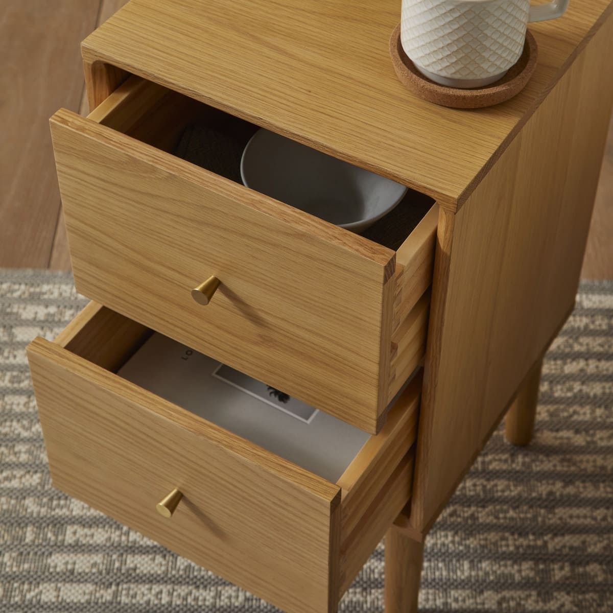 Wooden side table with open drawers on a patterned rug