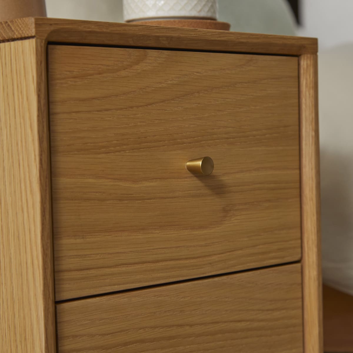 Wooden drawer with a gold handle on a wooden cabinet.