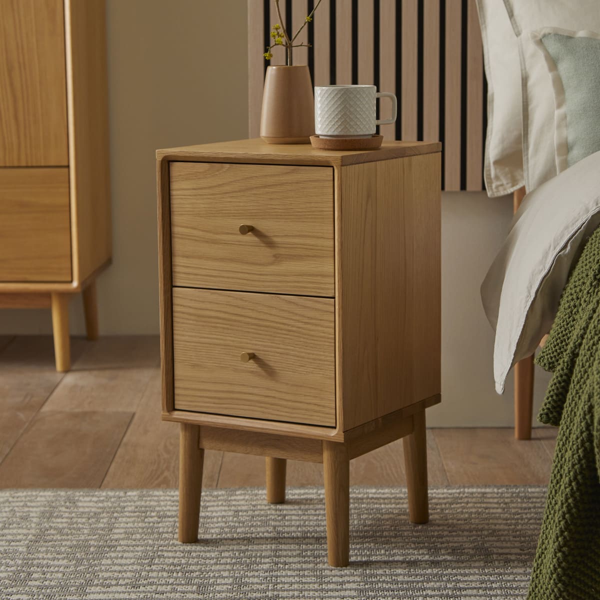 Wooden nightstand with two drawers in a bedroom setting