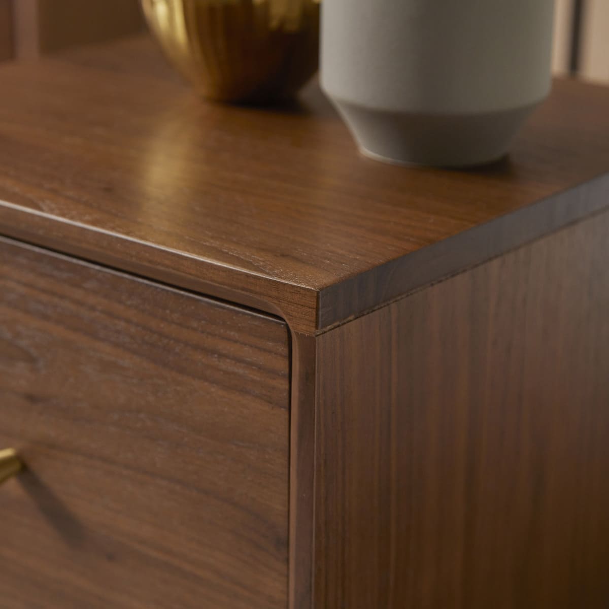 Wooden dresser with a gold handle and decorative items on top