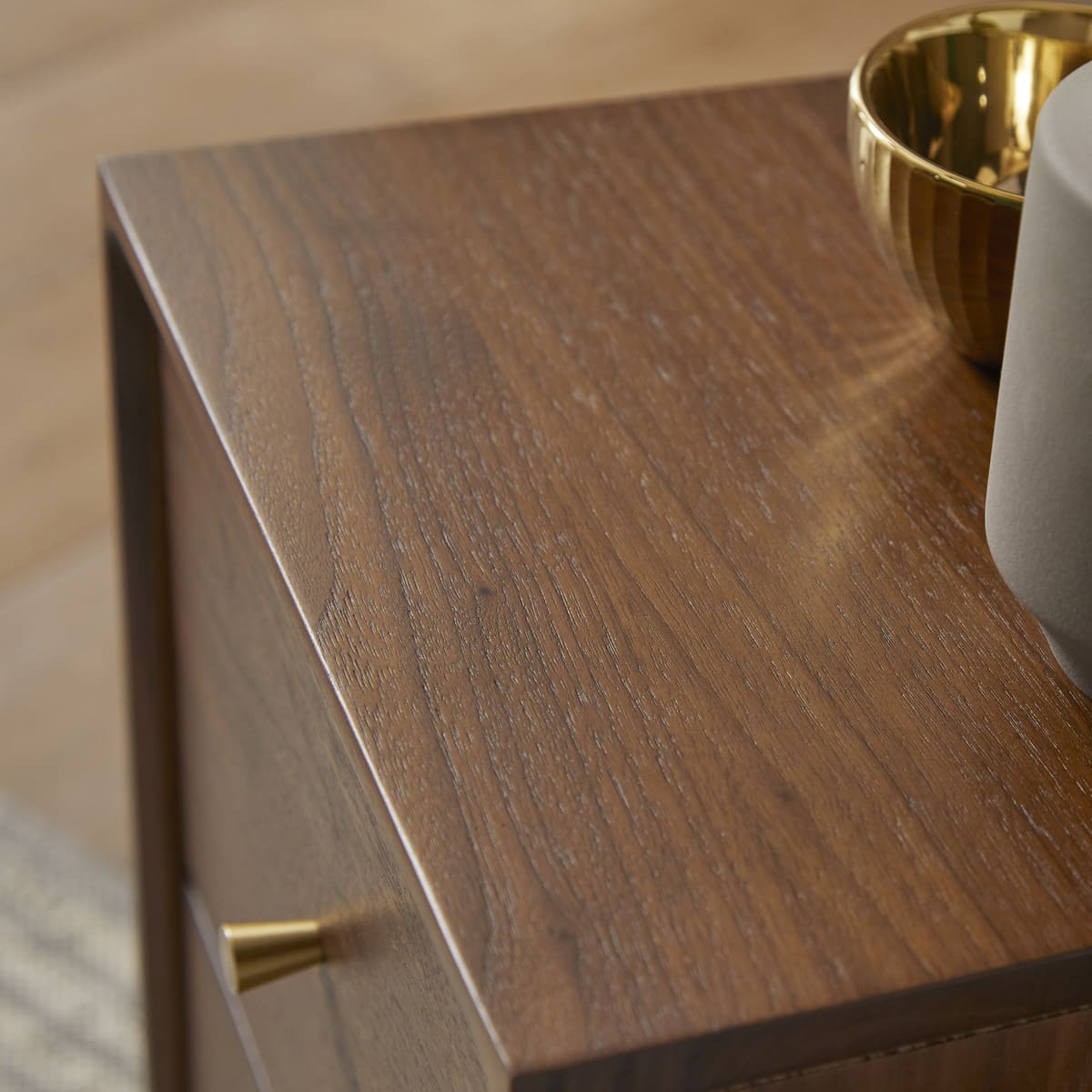 Wooden surface with a gold bowl and gray mug on a blurred background