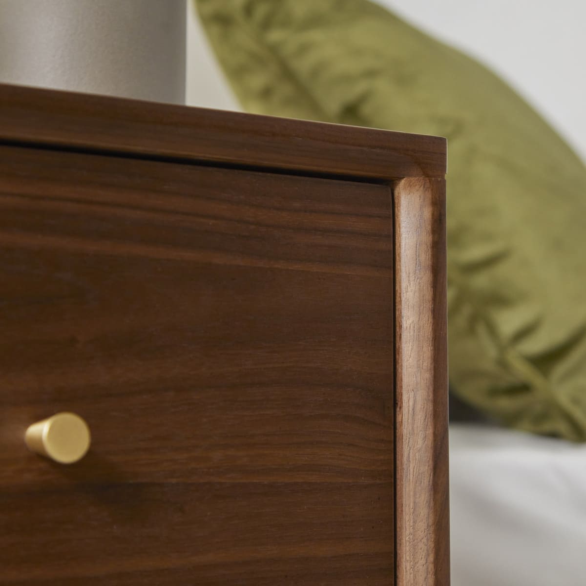 Wooden drawer with a gold handle in a bedroom setting