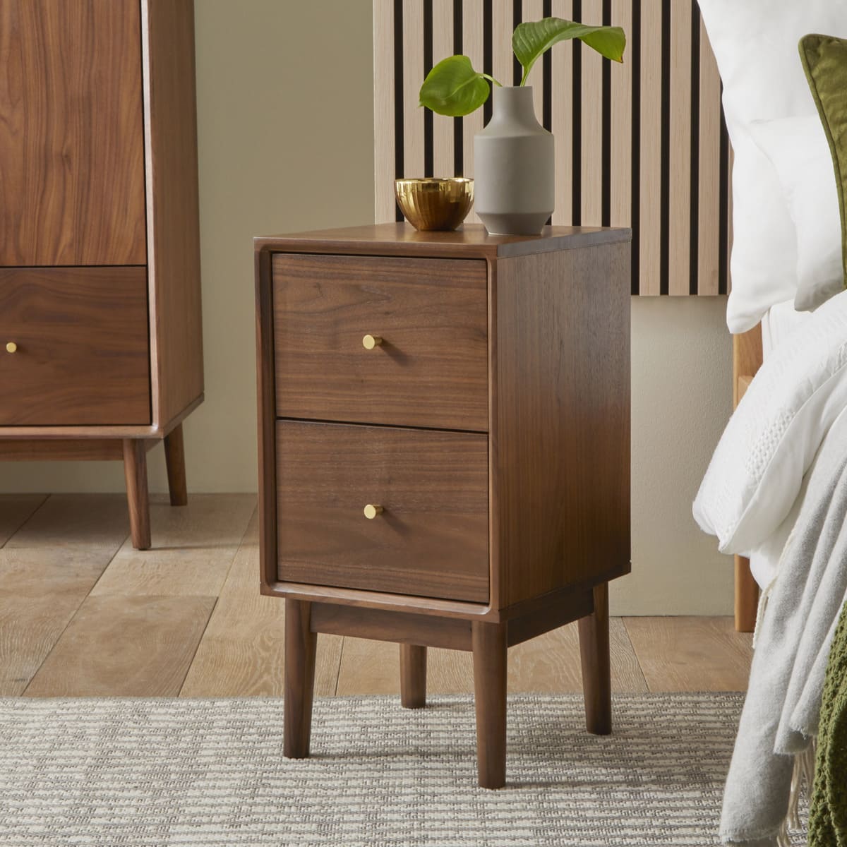 Wooden nightstand with two drawers in a bedroom setting