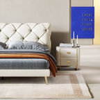 Modern bedroom with a tufted bed and side table, featuring a blue abstract painting.