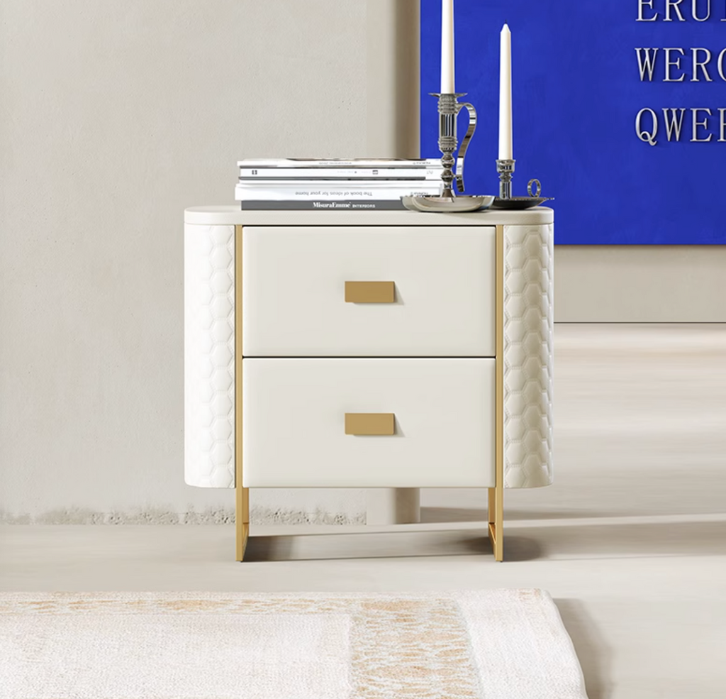 White nightstand with gold accents in a room with a blue wall and white rug.