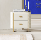 White nightstand with gold accents in a room with a blue wall and white rug.