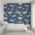 Pattern of cartoon whales, sharks, and narwhals on a blue background