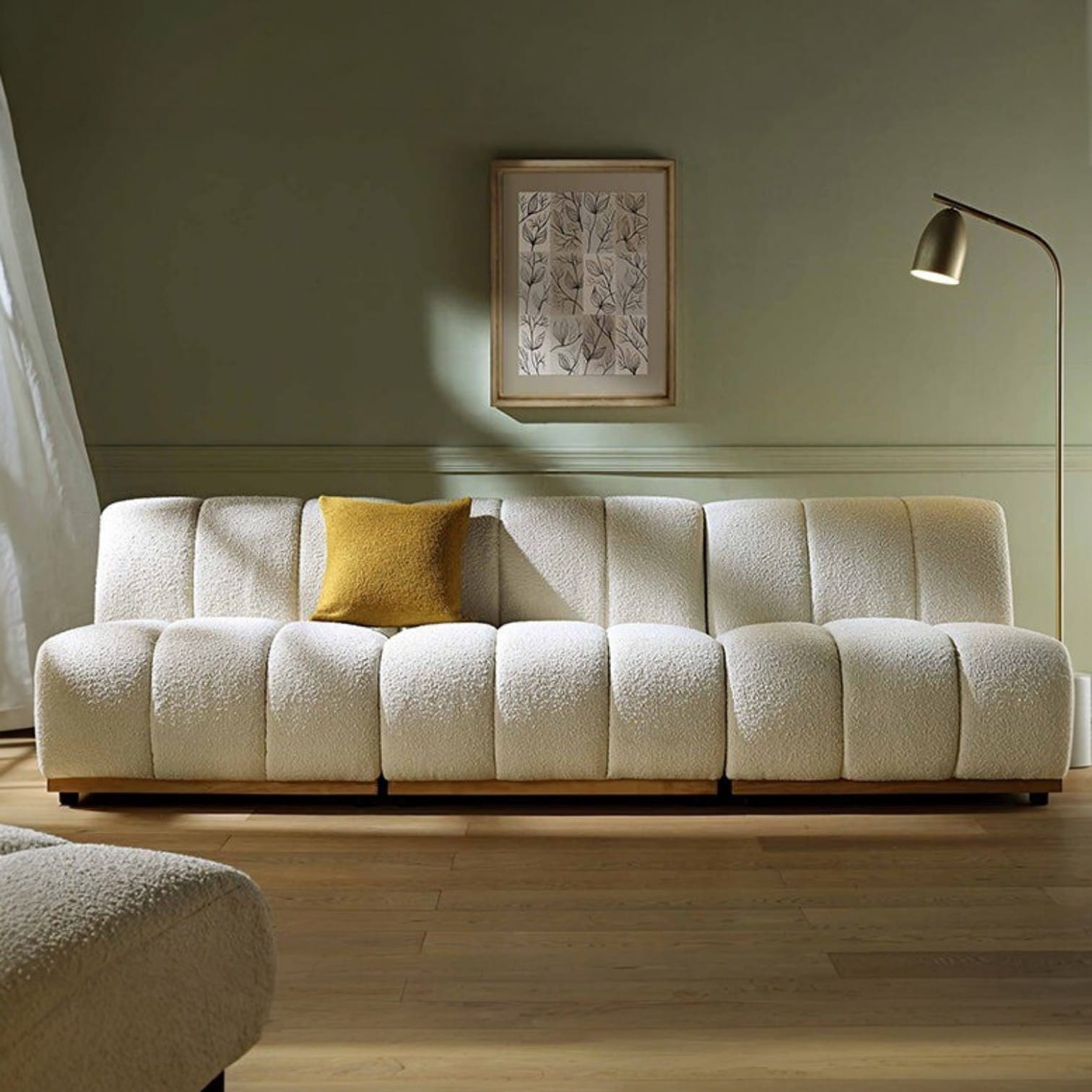White textured sofa with a yellow pillow in a room with a lamp and framed picture on the wall.