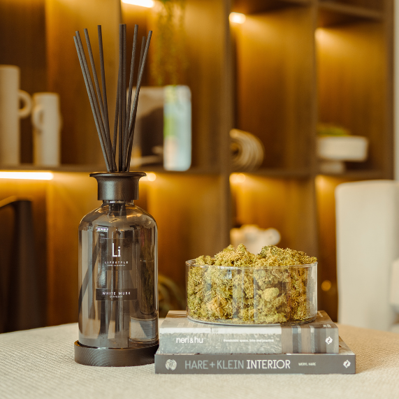 Decorative diffuser and small container on a table with a blurred background