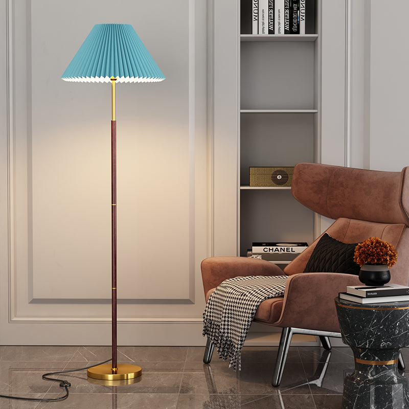 Modern living room with a floor lamp, armchair, and bookshelf.