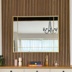 Wall mirror with gold frame on a wooden shelf against a striped wall.