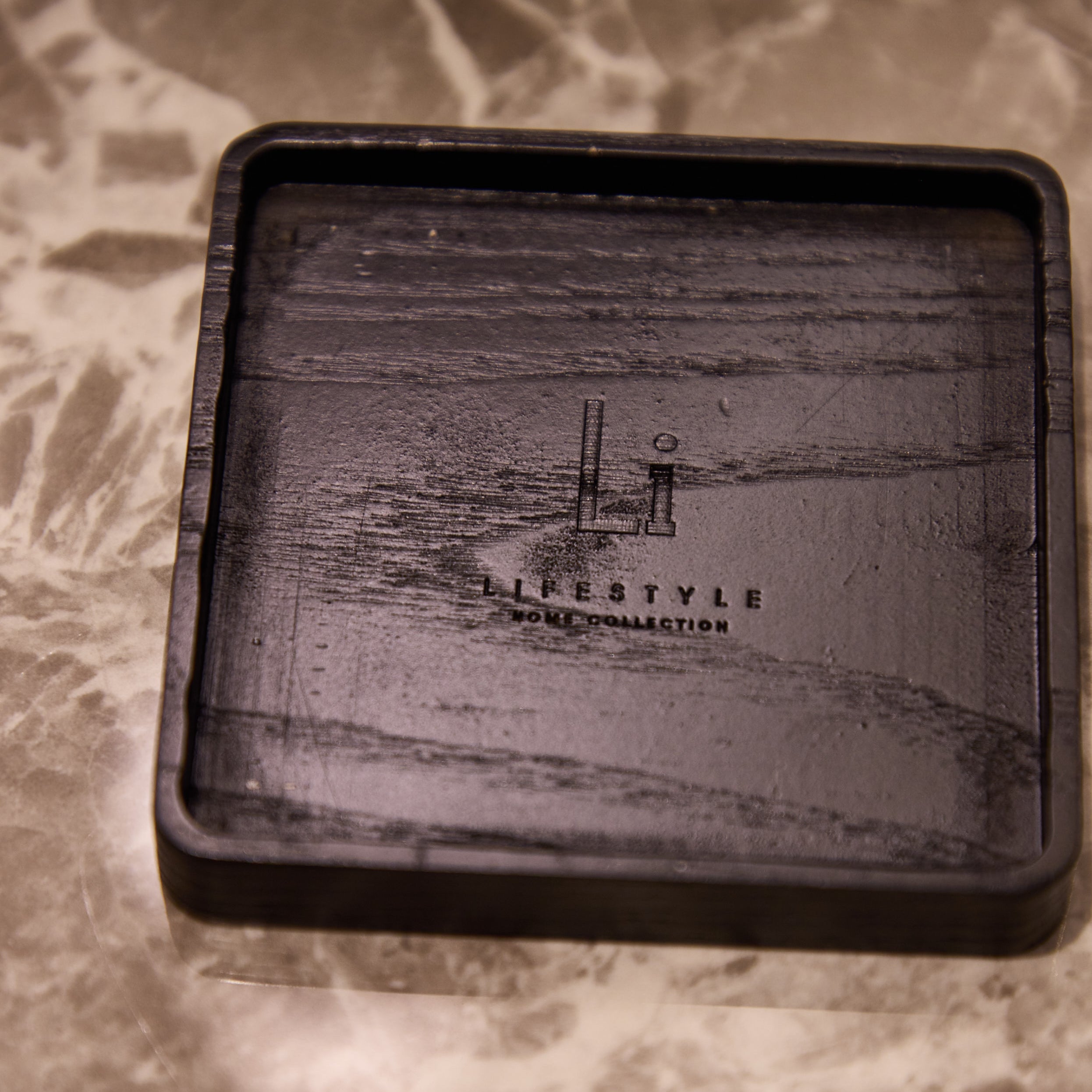 Black rectangular tray with 'Lifestyle Home Collection' branding on a marble surface