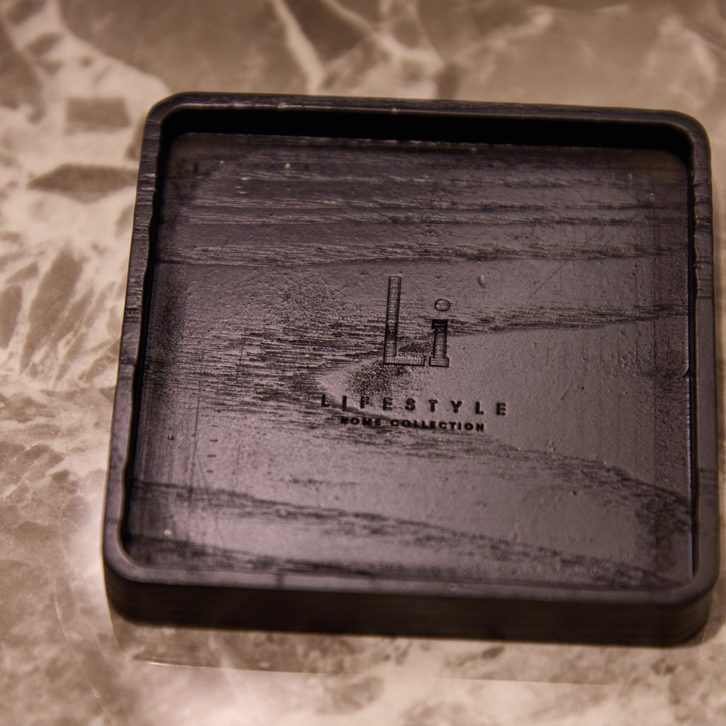 Black rectangular tray with engraved design on a marble surface