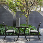 Outdoor patio set with two chairs and a table in a garden setting.