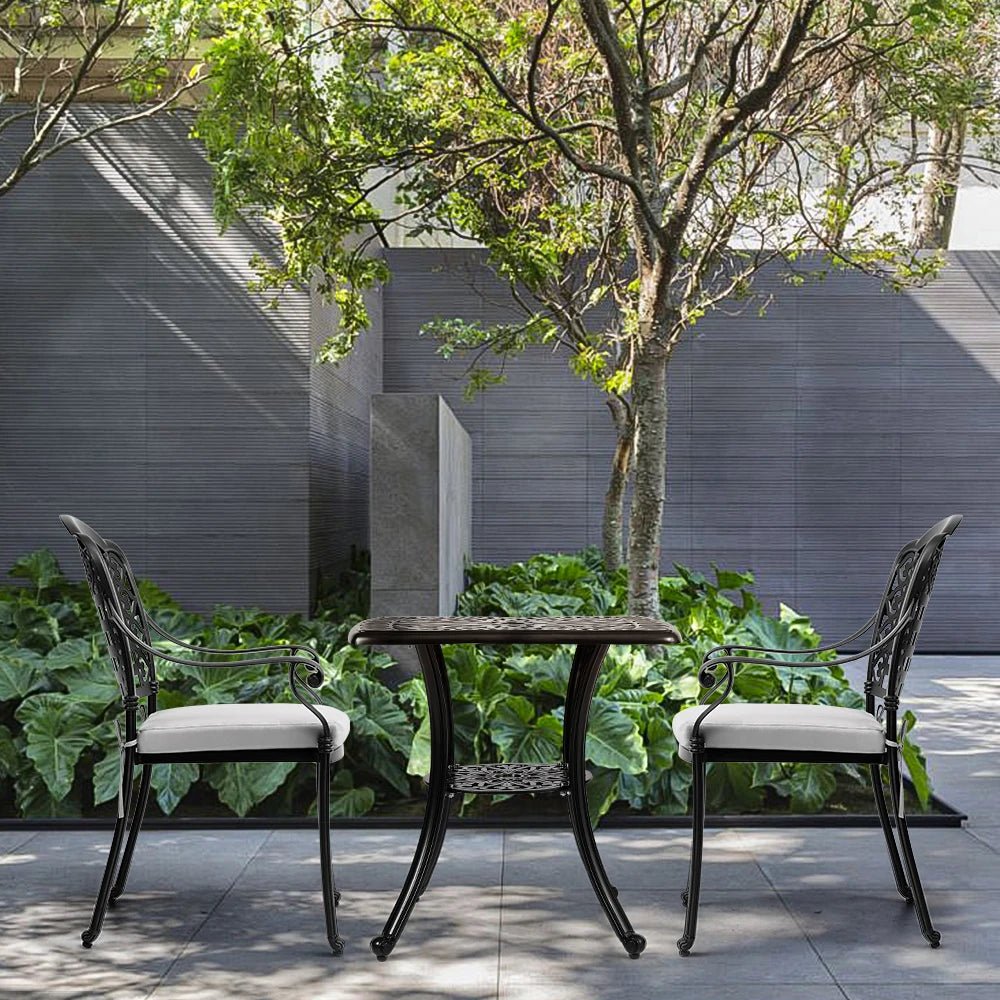 Outdoor patio set with two chairs and a table in a garden setting.