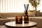 Candle and diffuser on a table in a living room setting