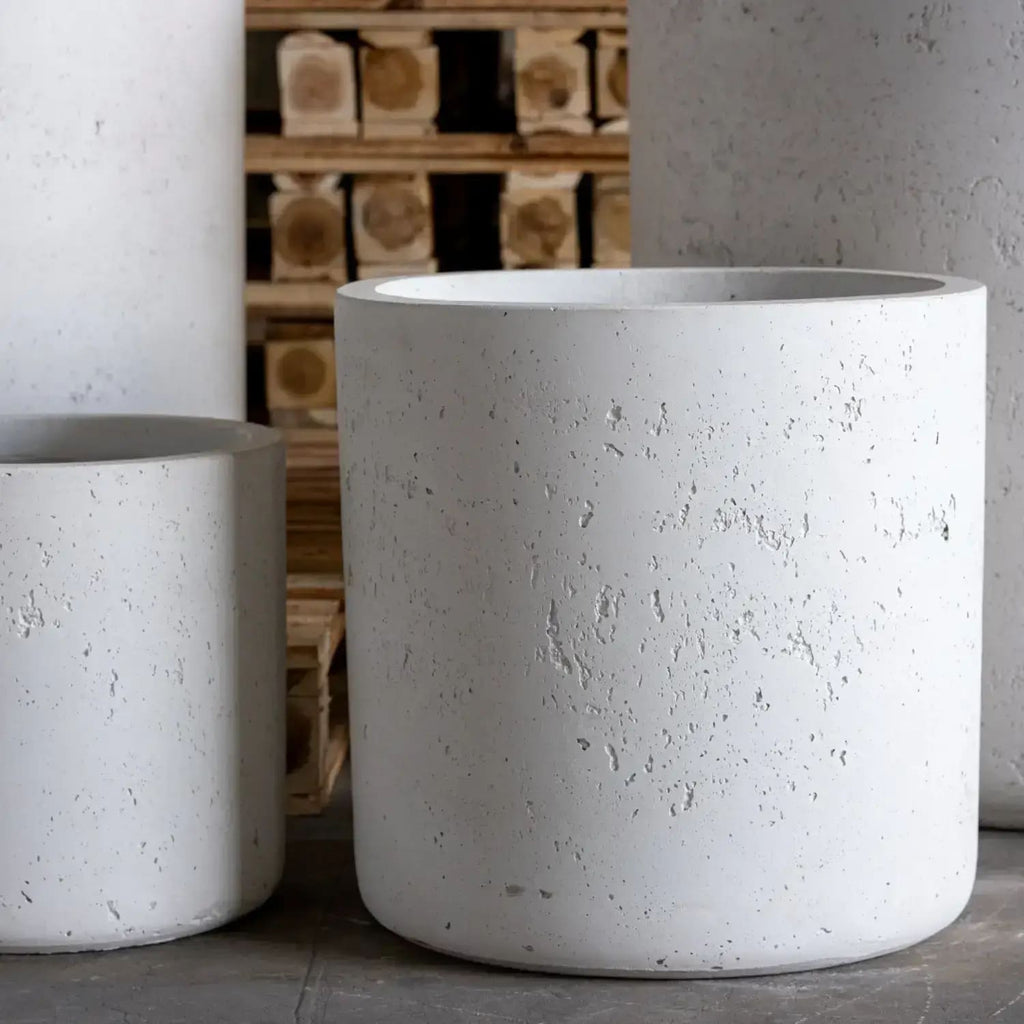 Two concrete planters on a wooden pallet background