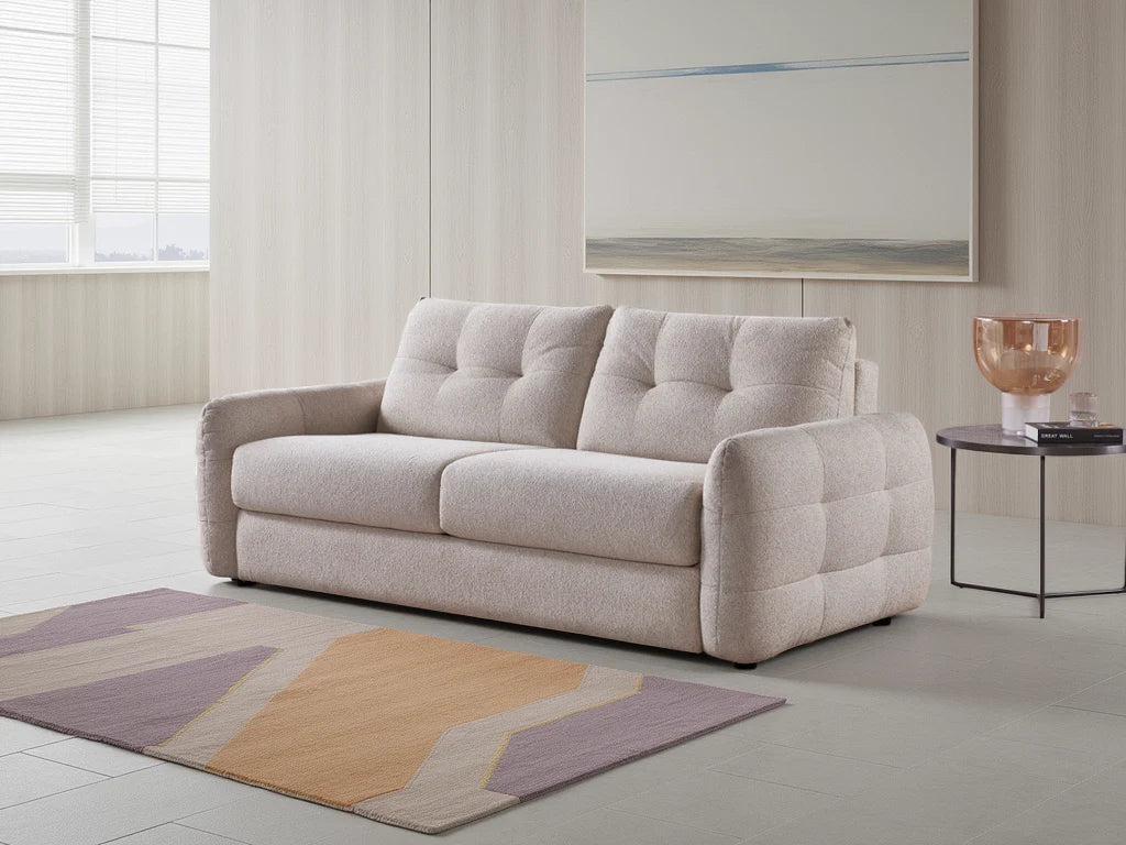 Beige sofa in a modern living room with a geometric rug and side table.