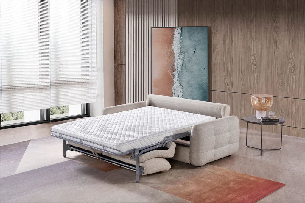Beige sofa bed in a modern room with large windows and abstract art on the wall.