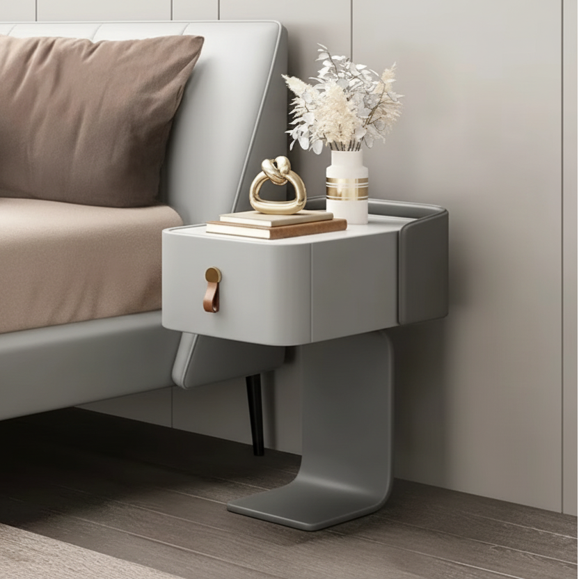 Modern gray nightstand with decorative items next to a bed
