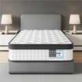 Mattress on a bed frame in a bedroom setting with lamps and nightstands.