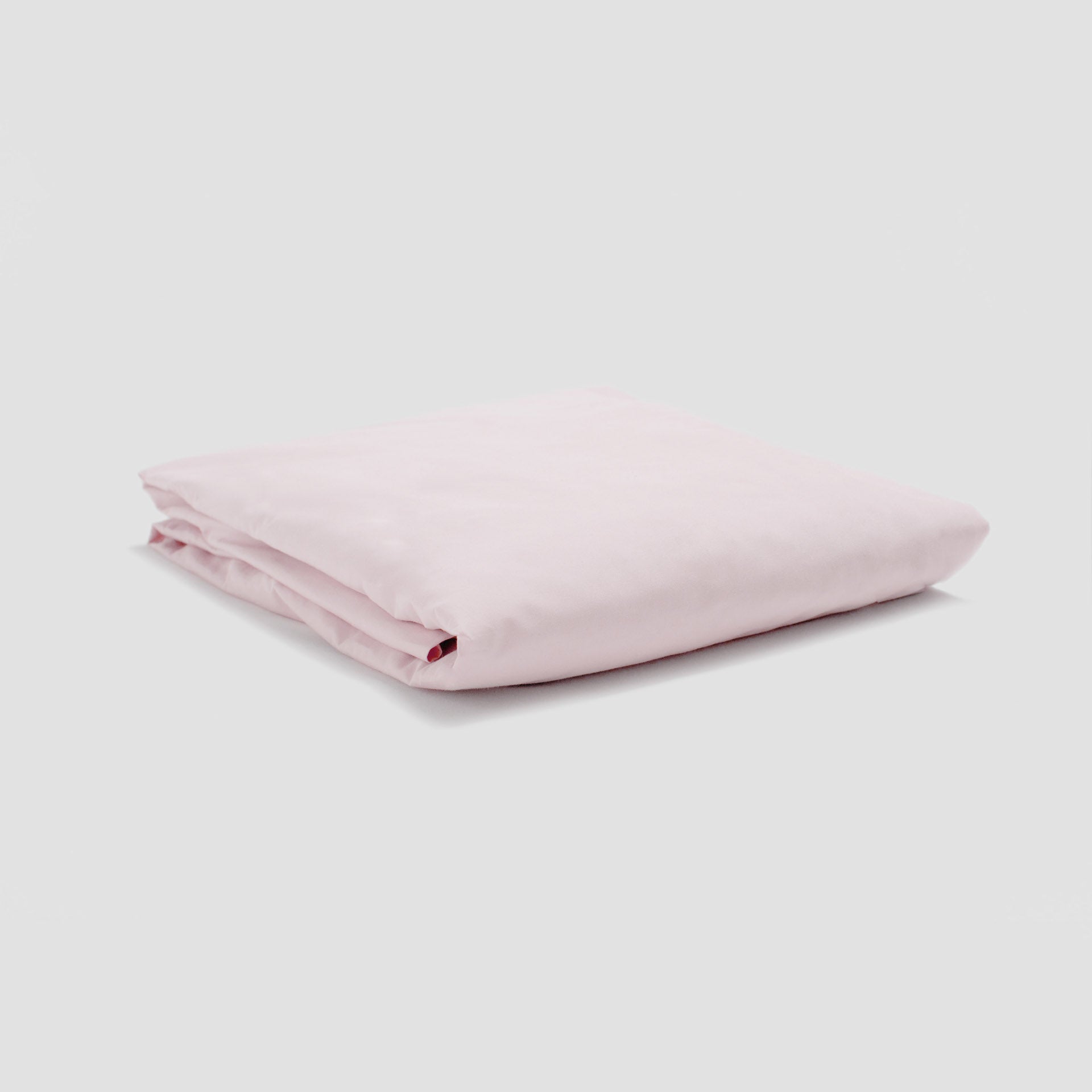 Folded pink fabric on a light gray background