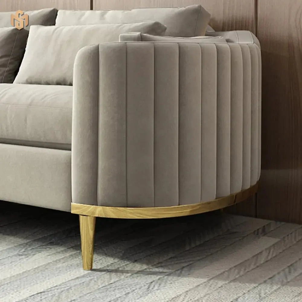 Gray tufted armchair with wooden legs in a living room setting