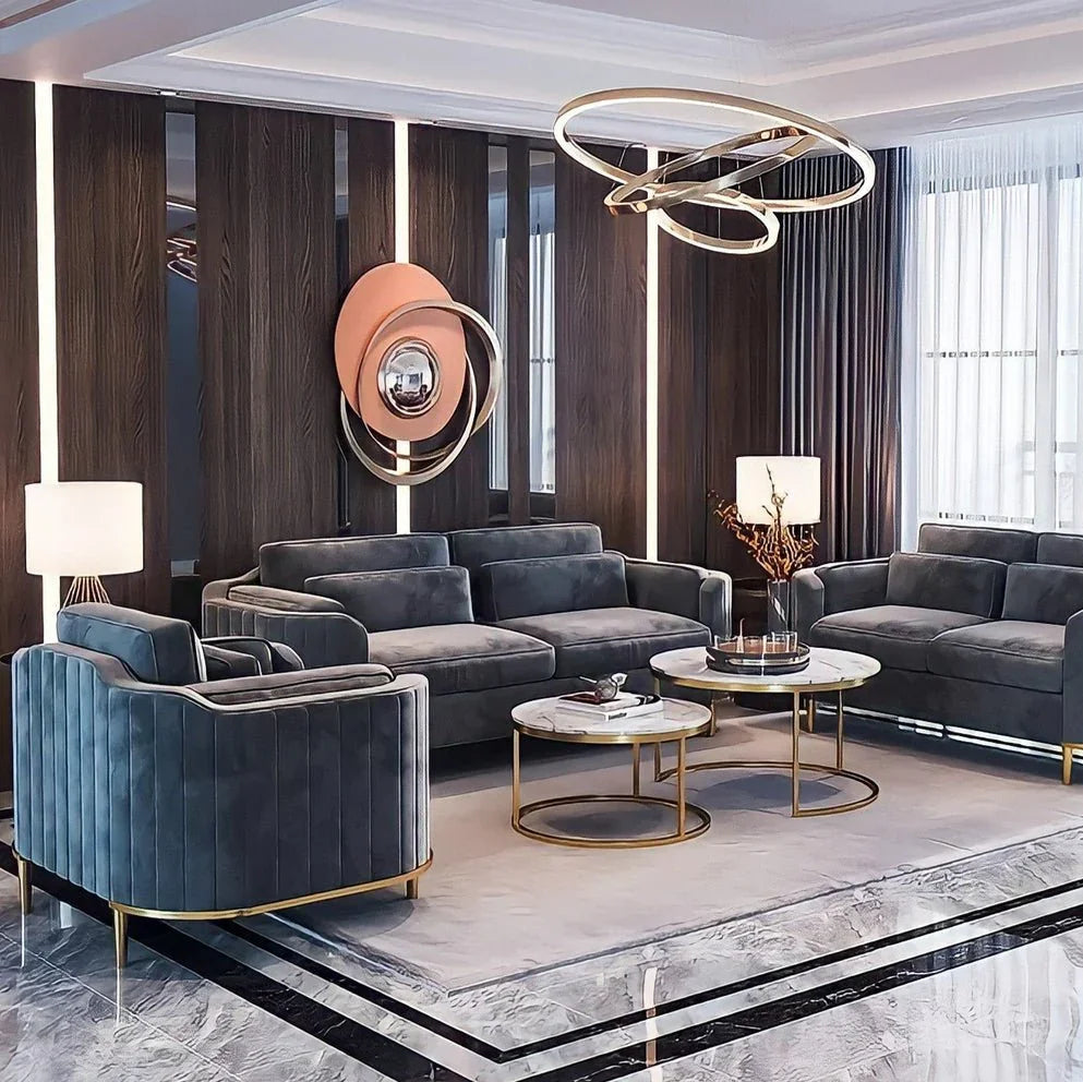 Modern living room with gray sofas, gold coffee tables, and decorative lighting.