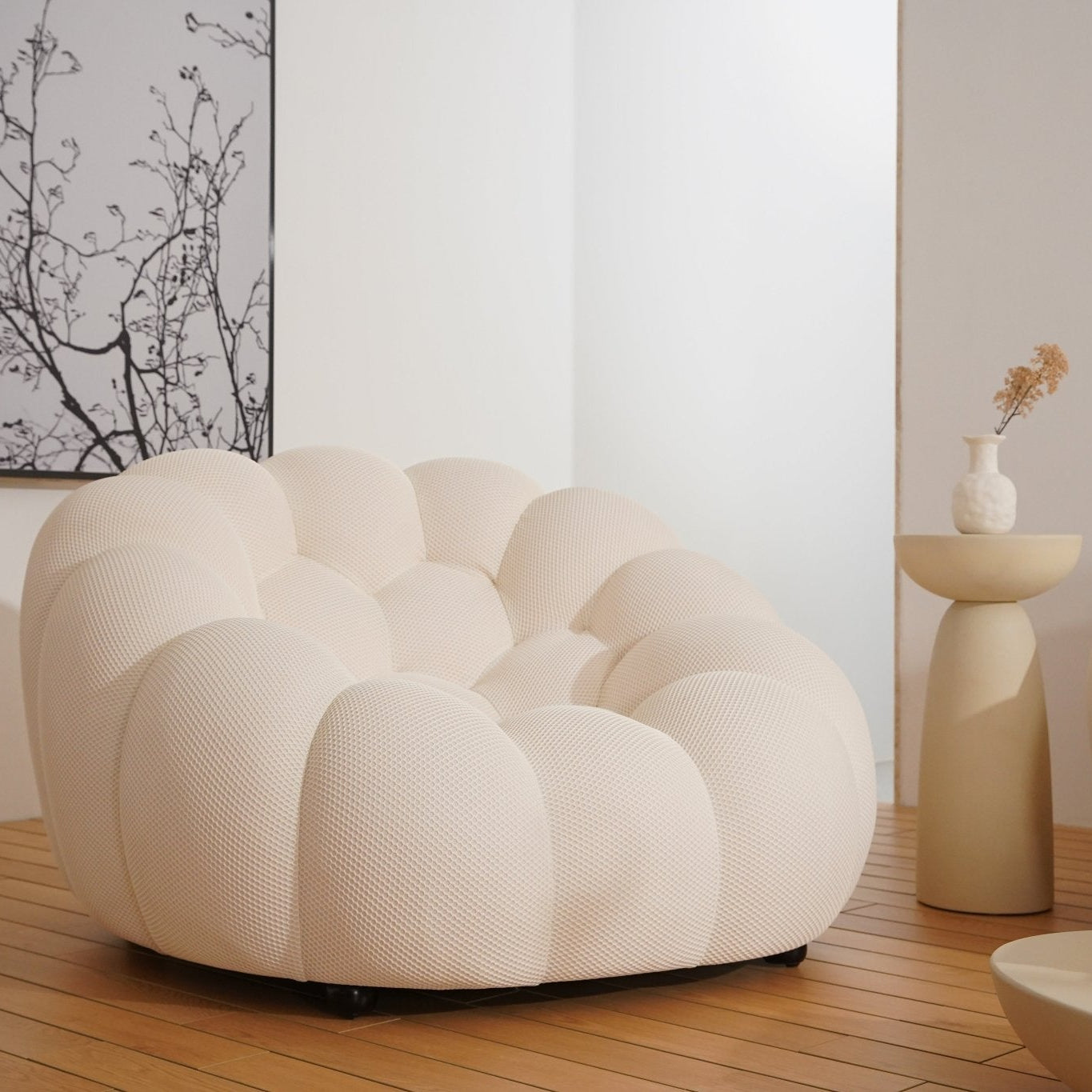 Modern white chair in a minimalistic room with wooden floor and white walls.