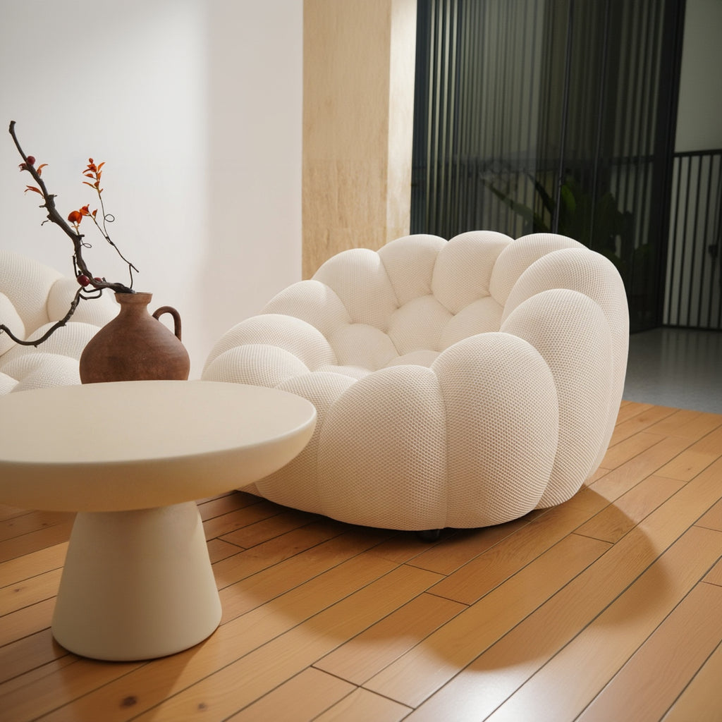 Modern white sofa in a living room setting with a vase and table.