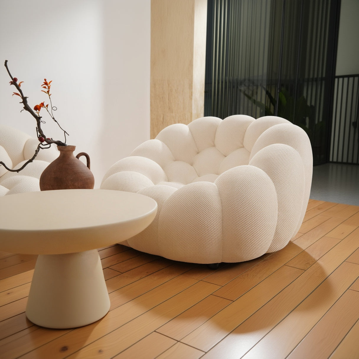 Modern white sofa in a living room setting with a vase and table.
