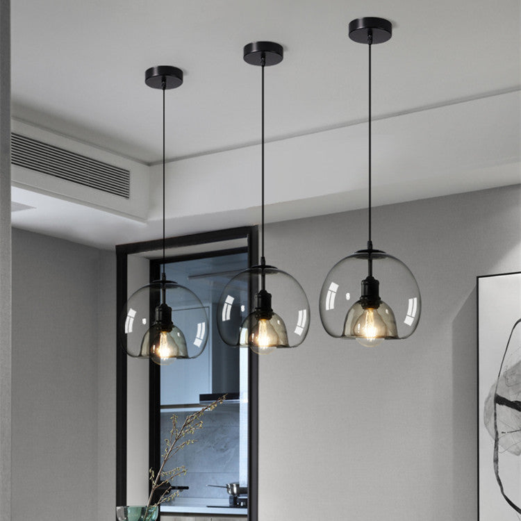 Modern pendant lights with glass shades hanging in a room.
