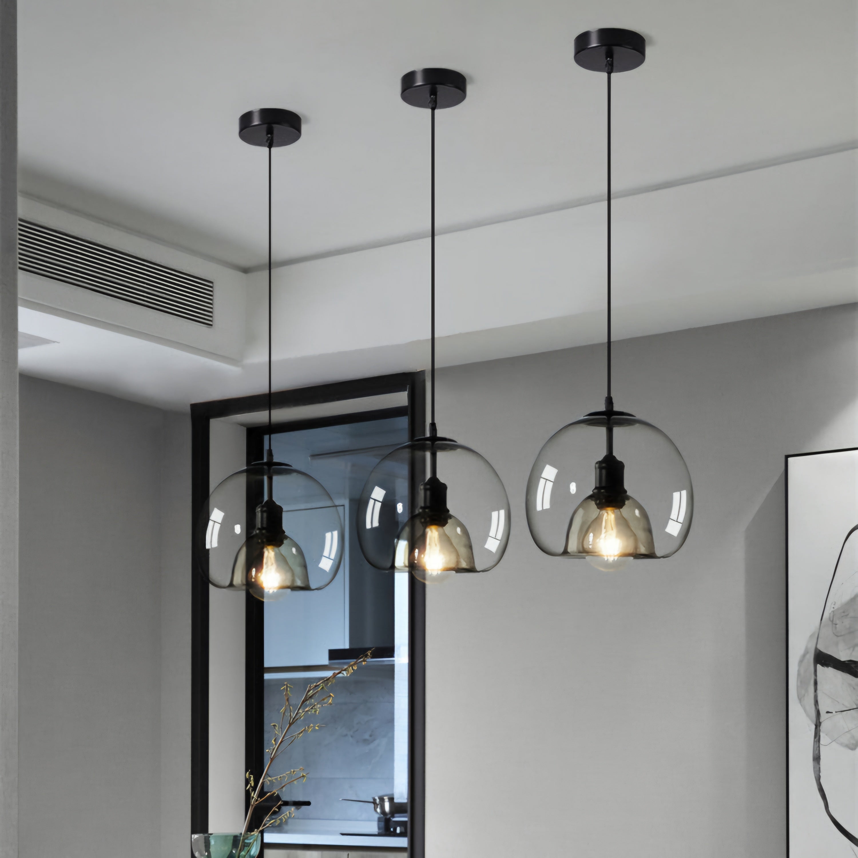 Modern pendant lights with glass shades hanging in a room.